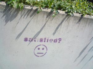 wall with the word satisfaction graffitied onto it
