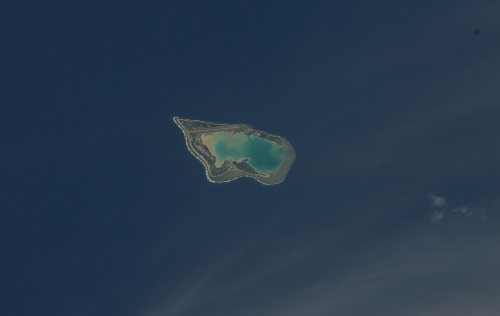 aerial shot of a deserted island in the middle of clear blue ocead