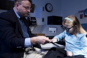 girl being tested at reading by specialist