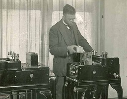 old picture of man using antique machine to process data