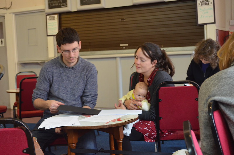 man intreviewing young mum with baby