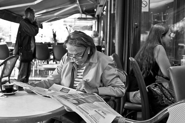 woman reading newspaper on a cafe