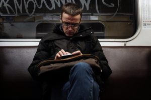 man struggling to read text on his phone