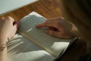 A reader using her finger to navigate a page of dense text