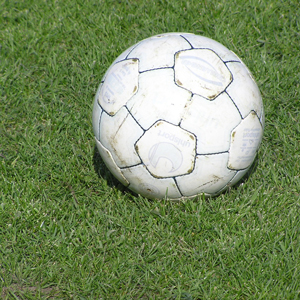 A worn-out football on a grassy area.
