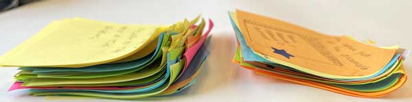A sideways view of two piles of sticky notes. One pile is about 4 times taller than the other.